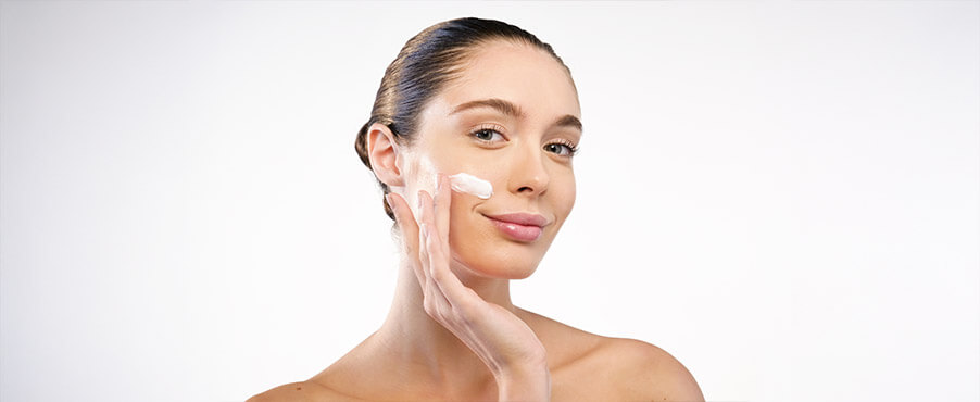 Młoda kobieta stosująca krem do twarzy z ceramidami