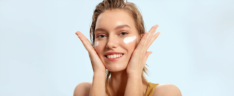 Młoda kobieta nakładająca na twarz krem ceramidowy