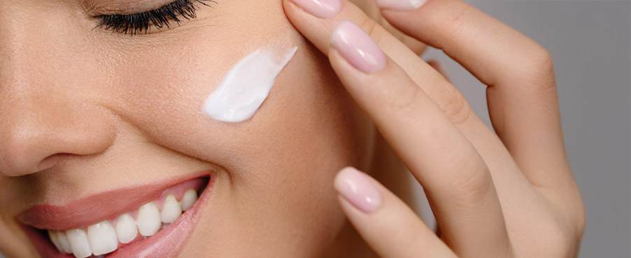 Kobieta nakładająca krem pielęgnujący na twarz